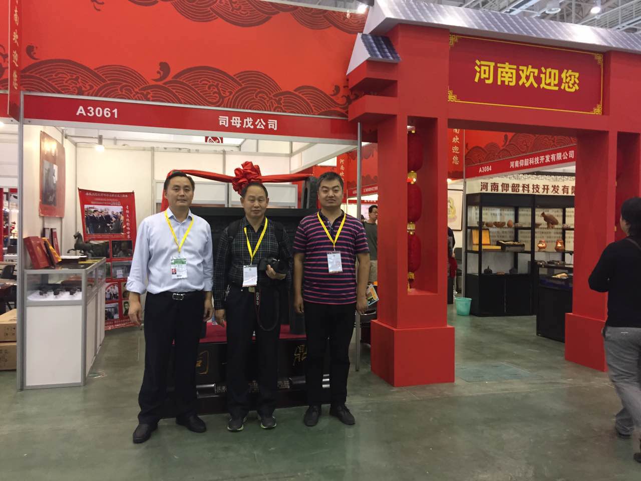 安陽市旅游局領(lǐng)導(dǎo)觀看展出的殷商文化展品，并在司母戊鼎前合影